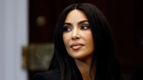 Getty Images A close up headshot shows Kim Kardashian as she looks away from camera with a serious look on her face at a roundtable discussion on criminal justice reform hosted by Vice President Kamala Harris in the Roosevelt Room at the White House on April 25, 2024 in Washington, DC.