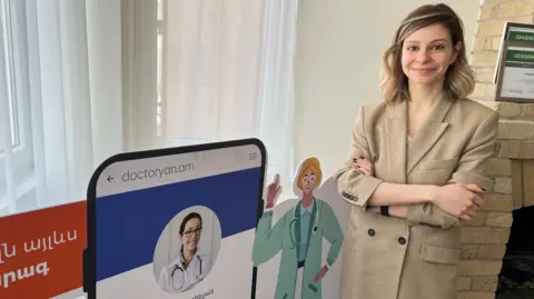 Irina Ghazaryan, the founder of medical app Dr Yan, smiles at the camera with her arms crossed
