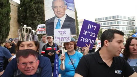 EPA A supporter of Israeli Prime Minister Benjamin Netanyahu hold up a picture of him and a banner saying