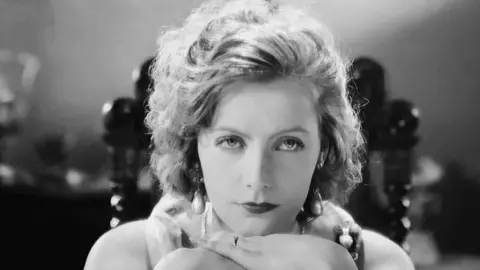 Getty Images Head shot of Greta Garbo looking serious in a black and white still from her film Love (1927)