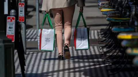 Getty Images A shopper carries shopping bags in the North Beach neighborhood in San Francisco, California, US, on Tuesday, March 11, 2025. 