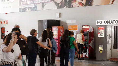 EPA People form a queue at a cash machine in Madrid