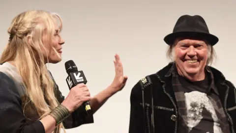 Getty Images Daryl Hannah and Neil Young share a joke on stage