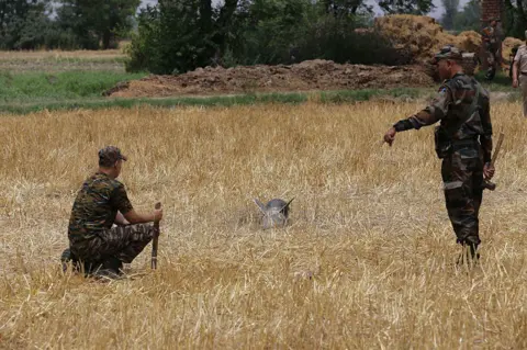 Getty Images Indian Army personnel secure the site where missile debris was found in a field, following what the authorities described as an overnight aerial assault by Pakistan involving
