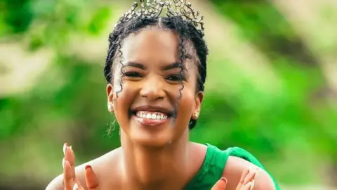 Lesego Chombo/Instagram Lesego Chombo in a diamond tiara smiles - she's wearing a green dress with a single strap against a green background
