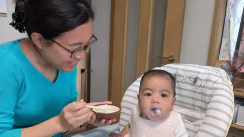 Memori Higuchi Memori Higuchi feeding her 7-month-old baby.