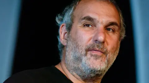 Alamy Alan Yentob is seen in a head and shoulders photo against a blue background