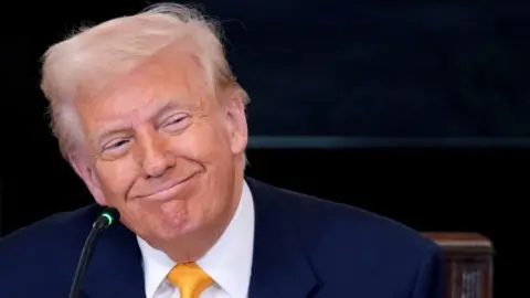 Getty Images A smiling Trump at a lectern